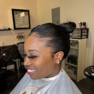 A sculpted high bun with laid edges